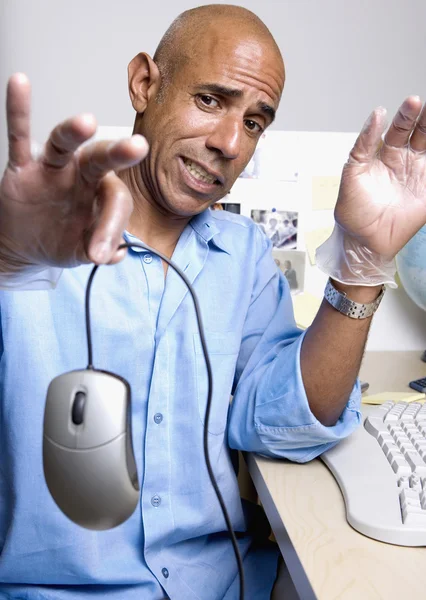 Middle-aged African businessman holding computer mouse