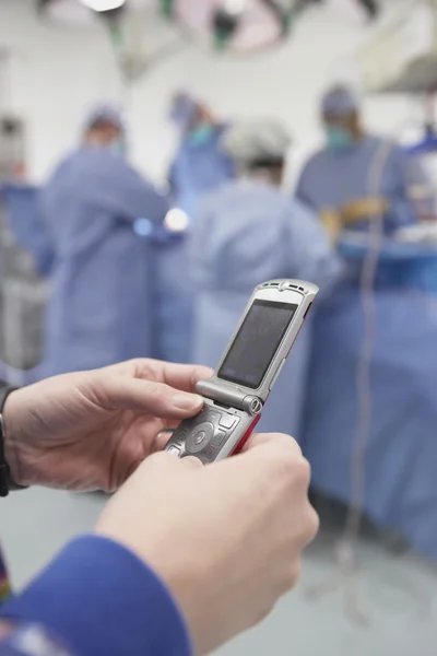 Close up of doctor using cell phone in operating room