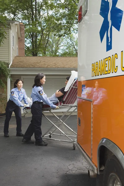 Paramedics putting woman into ambulance