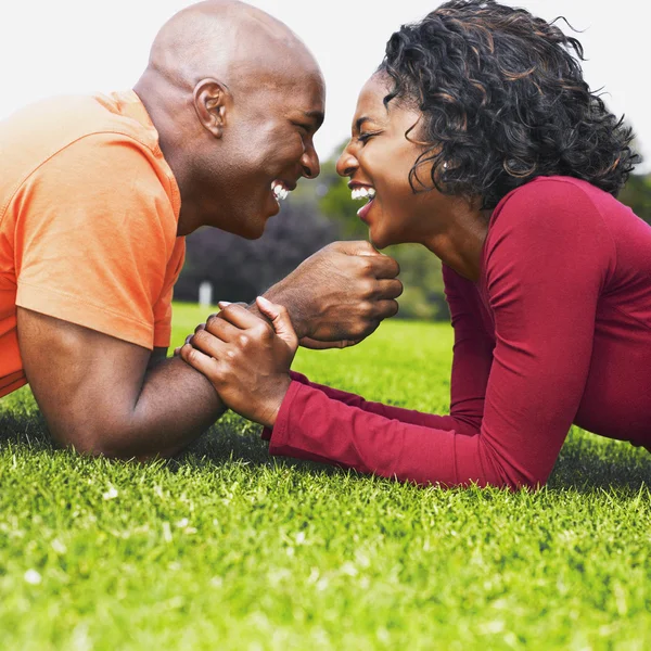 African couple laughing in grass