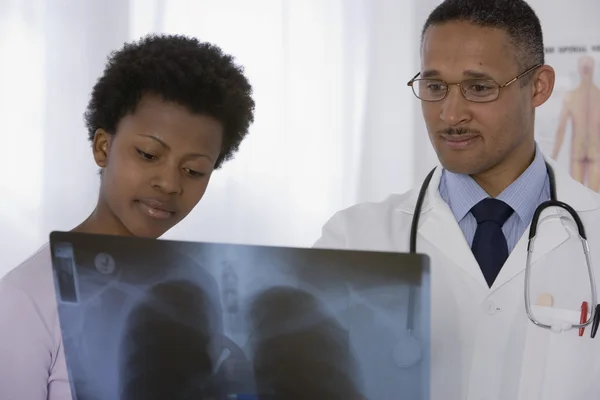 African male doctor and patient looking at x-ray