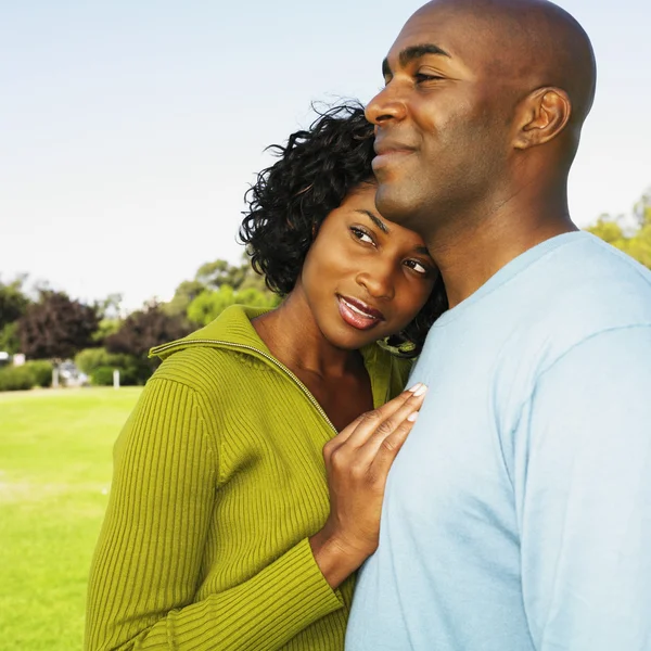 African couple hugging outdoors