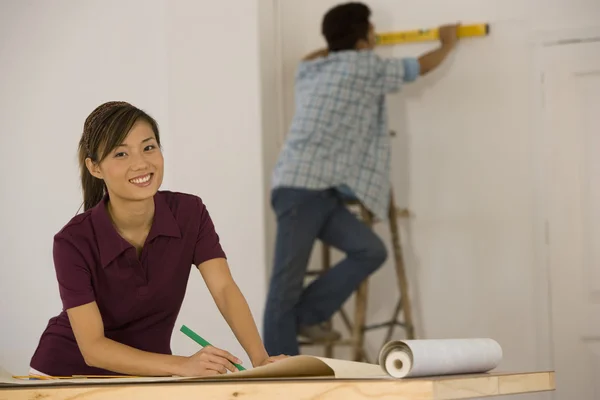 Asian couple hanging wall paper