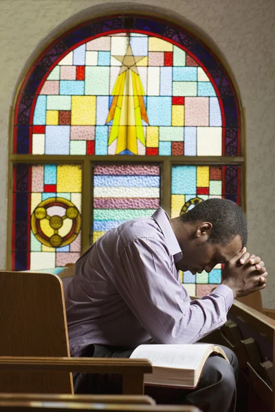 African American man praying in church