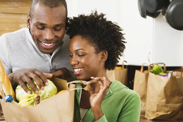 African American couple looking in grocery bag