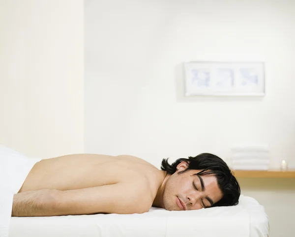 Asian man laying on massage table