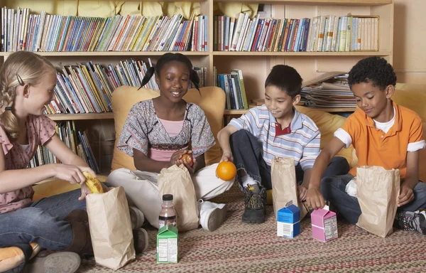 Multi-ethnic school children eating lunch