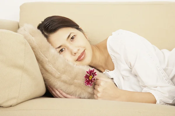 Asian woman laying on sofa