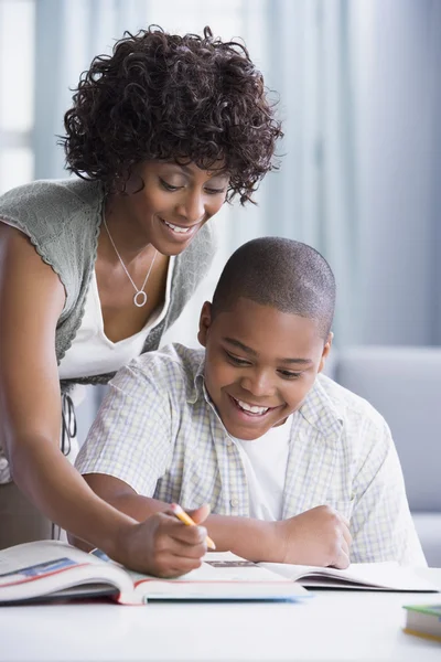 African American mother helping son with homework