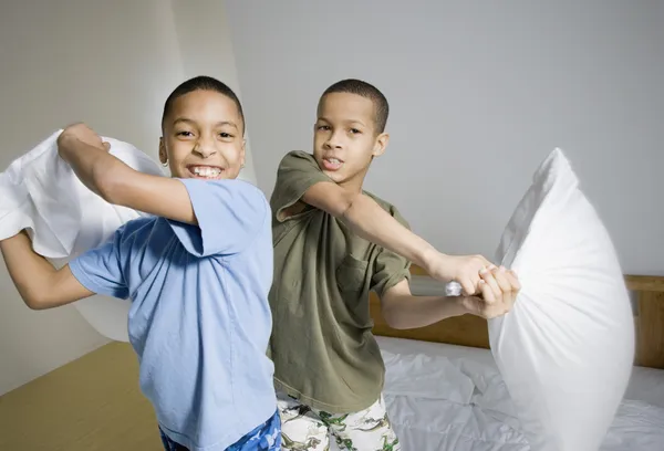 African American brothers having pillow fight
