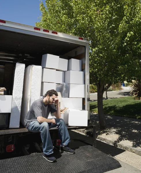 Middle Eastern man sitting on moving truck
