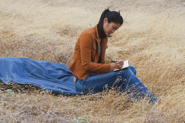 Asian woman writing in journal