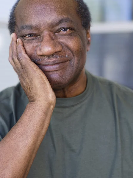 Senior African man resting chin on hand