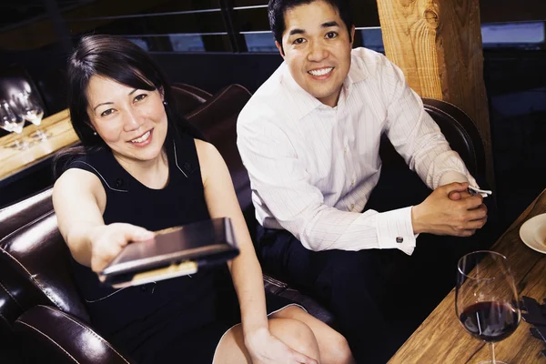Asian couple paying restaurant bill