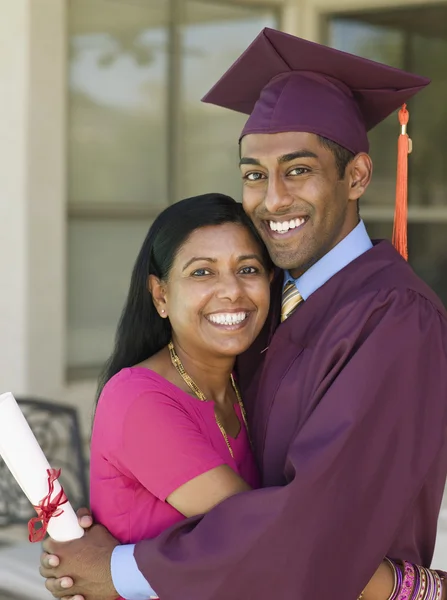 Indian mother hugging graduate son