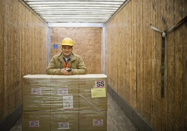 Asian warehouse worker with shipment in truck