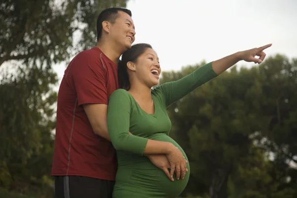 Pregnant Asian couple hugging
