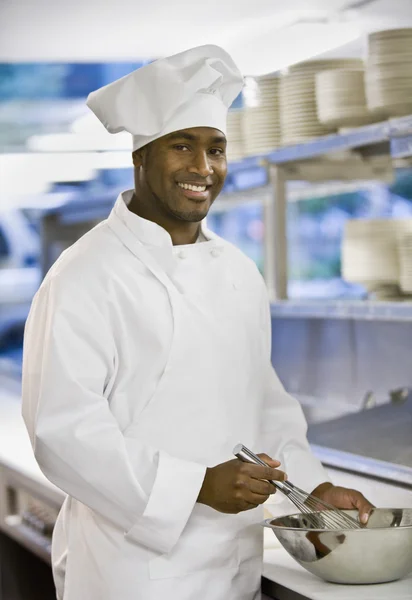 African man chef whisking food