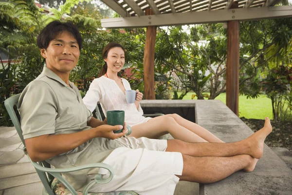 Asian couple on patio with coffee