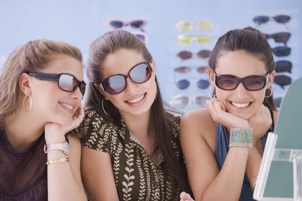 Multi-ethnic teenaged girls trying on sunglasses — Stock Photo #23323810