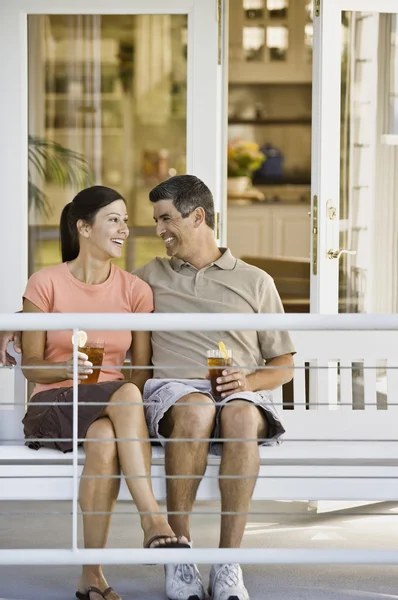 Multi-ethnic couple sitting on porch swing