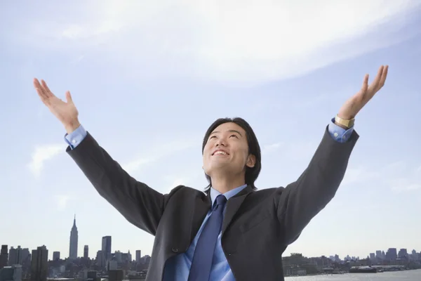 Asian businessman with arms raised