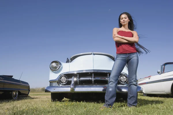 Mixed Race woman in front of low rider car