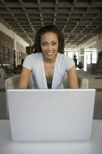 African American woman sitting behind laptop