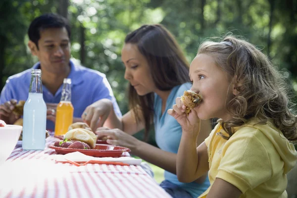 Hispanic family eating at picnic table