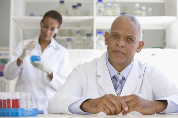 African scientist in laboratory with co-worker in background