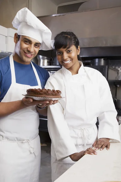 Multi-ethnic pastry chefs with cake