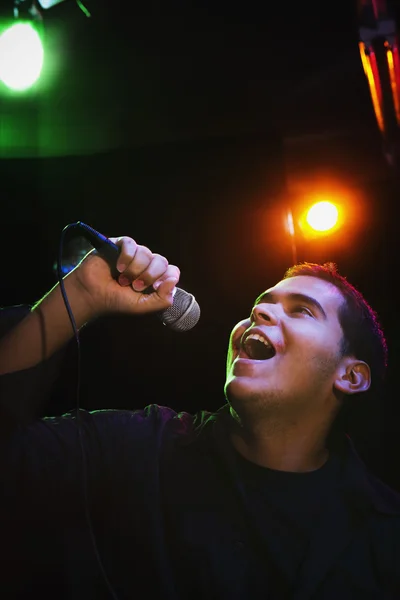 Hispanic man singing in nightclub