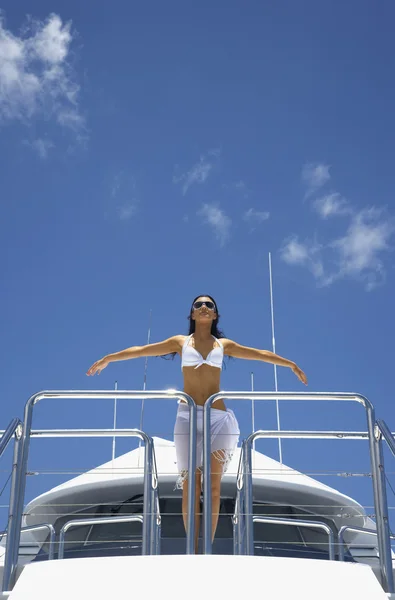 Pacific Islander woman on boat with arms outstretched