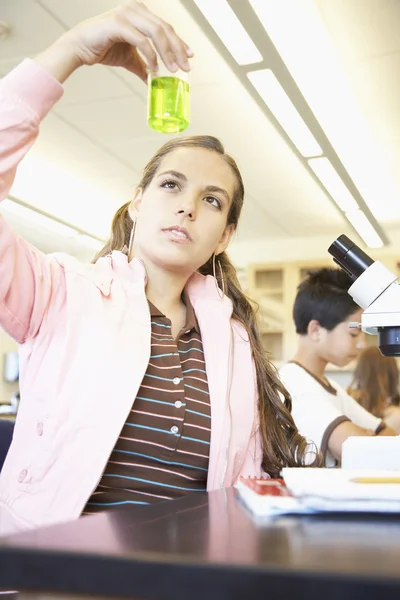 Teenaged girl with beaker in science class