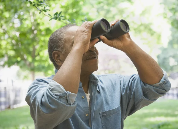 African man looking through binoculars outdoors