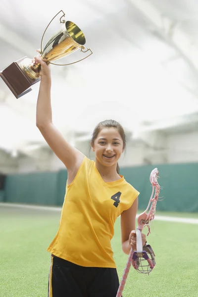 Mixed race girl lacrosse player holding trophy