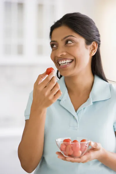 Indian woman eating tomato