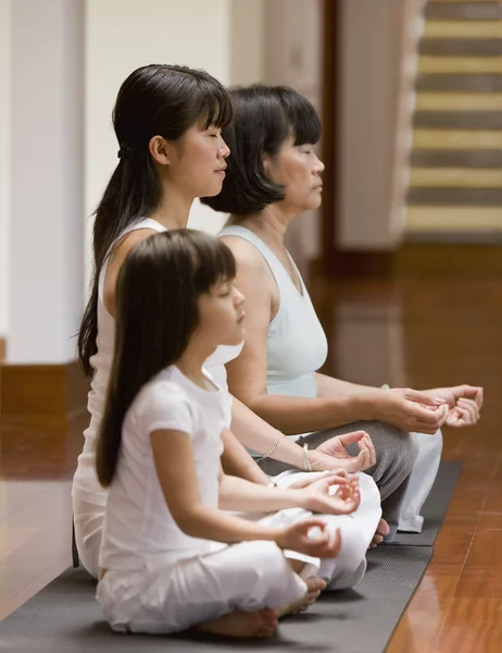 Asian family practicing yoga