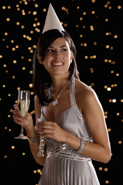Hispanic woman drinking champagne on New Year's Eve