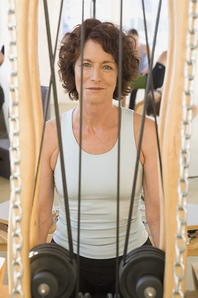 Senior woman sitting in exercise equipment
