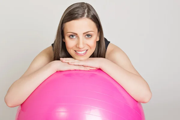 Happy fitness girl relaxing on fitness ball