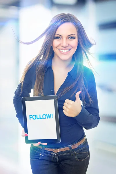 Cute young woman holding tablet that states follow