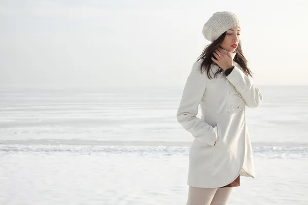 Emotive portrait of a fashionable model in white coat and beret