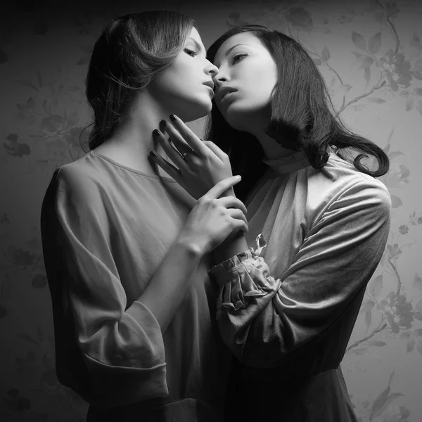 Retro portrait of two gorgeous women (girlfriends) kissing in gr