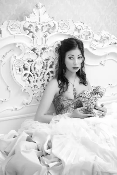 Vintage portrait of a beautiful queen like girl in the white bed