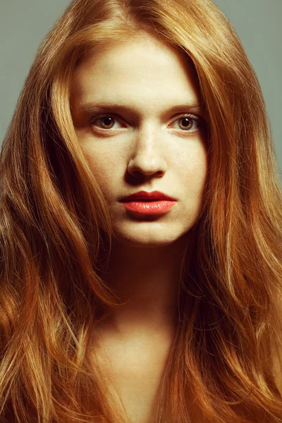 Emotive portrait of a fashionable model with red (ginger) curly