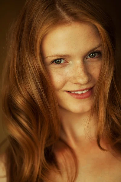 Portrait of a smiling beautiful red-haired (ginger) girl with fu