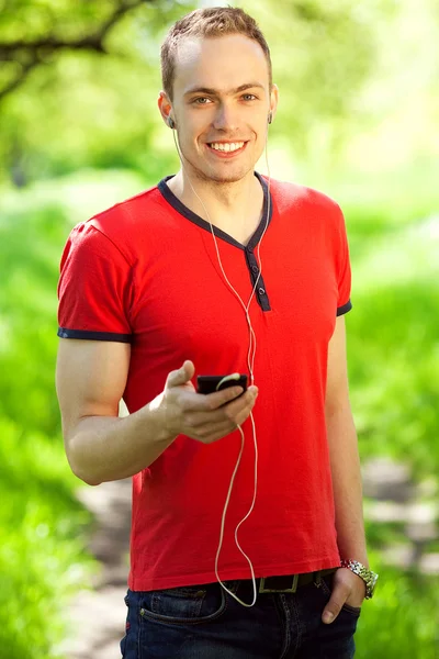 Gadget freak concept. Portrait of a young muscular man in red t-