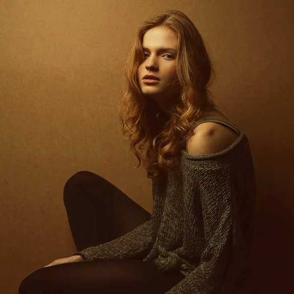 Emotive portrait of fashionable model with curly red hair and na