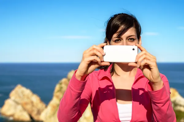 Woman taking photo with cellphone on summer